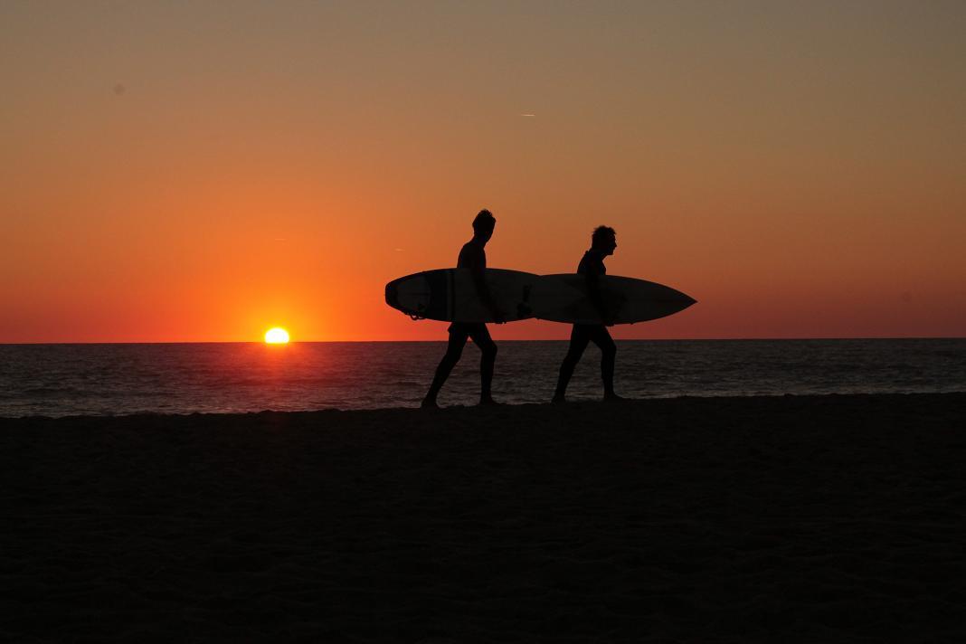 A photo of surfers in the sunset by Sean Keenan