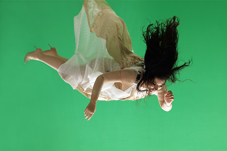 woman falling against green background