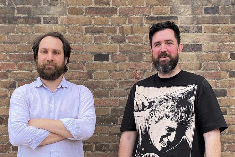 portrait of two men in front of a wall