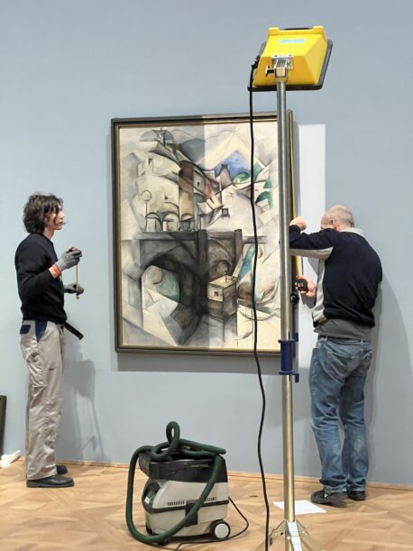 Curators installing an artwork from Ukraine featured in the exhibition In the Eye of the Storm, Vienna