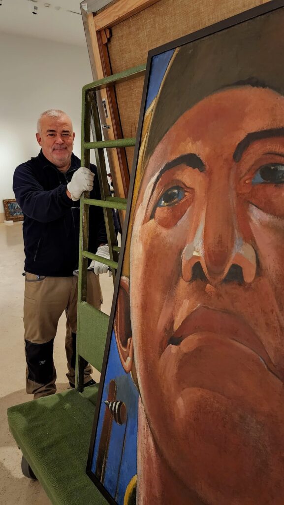 Photo of a museum worker in Madrid unpacking Kostjantyn Jelewa’s Self-Portrait (1920s), oil on linen,145 × 100 cm. Photo by Konstantin Akinsha. Artwork from Ukraine