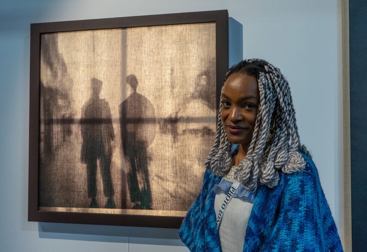 Barbara Ayozi in front of her photo. Photo London 2026 Olympia. Photo by Julio Etchart